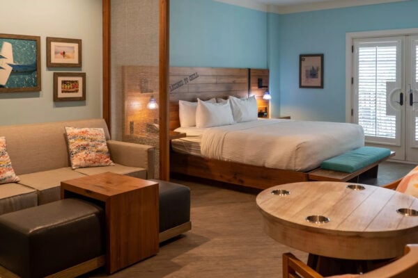 Guest room with king bed, wood headboard, sofa seating area, and French doors at Margaritaville Island Hotel Pigeon Forge