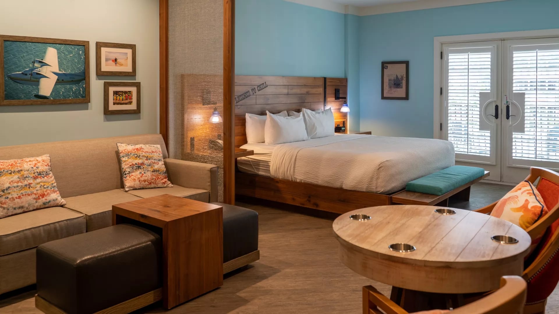 Guest room with king bed, wood headboard, sofa seating area, and French doors at Margaritaville Island Hotel Pigeon Forge