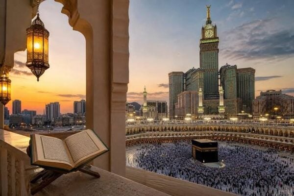 Kaaba at Masjid al-Haram in Makkah with the Makkah Royal Clock Tower and an open Quran in the foreground.
